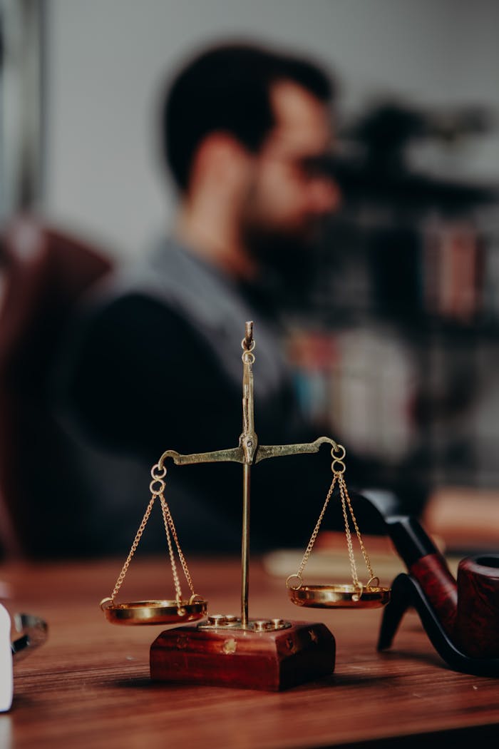 our-stories Close-up of justice scales and pipe on a lawyer's desk, emphasizing legal themes.